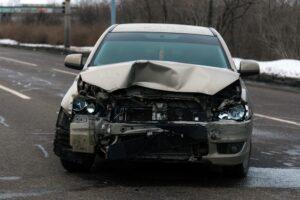 : A smashed front-end of a car. How long do car accident settlements take?